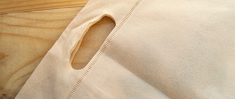 千庫(kù)網(wǎng)_放棄塑料袋的概念，無(wú)紡布生態(tài)袋，平鋪在淺色木質(zhì)背景上，頂視圖，復(fù)制空間_攝影圖編號(hào)14950906